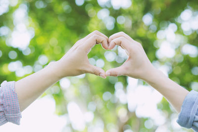 Midsection of woman holding heart shape leaf