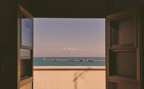 Scenic view of sea against sky seen through window