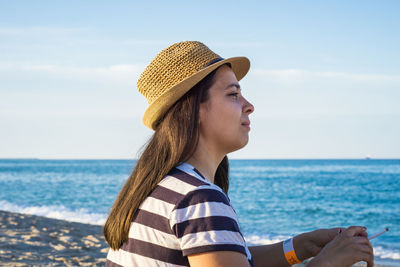 Portrait of beautiful woman against sea against sky
