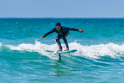 Man surfing in sea against sky