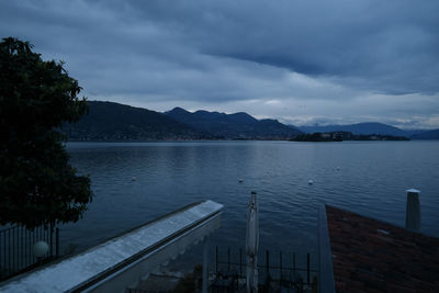 Scenic view of lake and mountains against cloudy sky