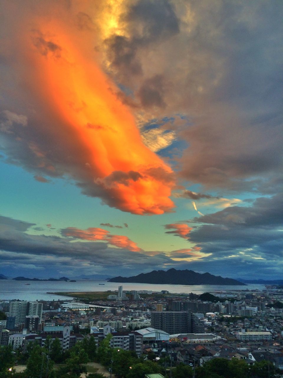 building exterior, architecture, cityscape, sky, built structure, city, sunset, cloud - sky, residential district, high angle view, crowded, cloudy, residential building, residential structure, cloud, town, orange color, dramatic sky, scenics, townscape