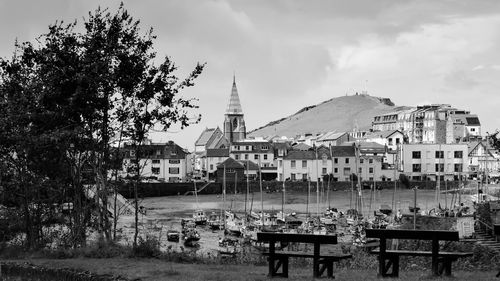 Black and white shot empty benches with buildings in background at ilfracombe harbour