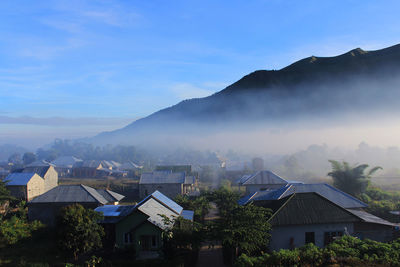 Houses by mountains against sky