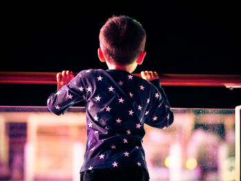 Rear view of boy playing at music concert