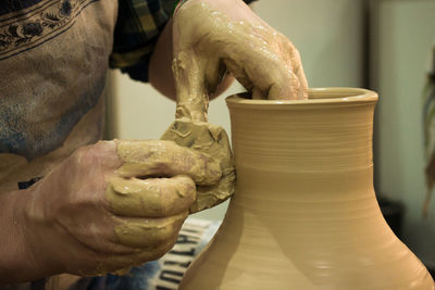 The potter molds clay jug pot closeup. workshop on sculpt white clay closeup. dirty hands in clay. 