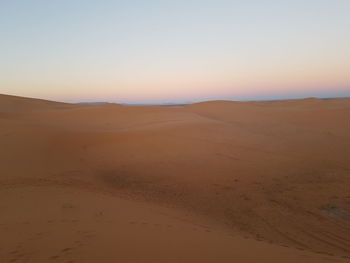 Scenic view of desert against sky during sunset