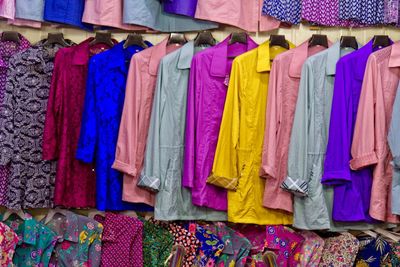 Multi colored clothes hanging on display at store