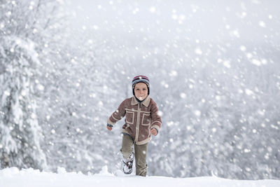 Portrait of woman standing on snow covered field