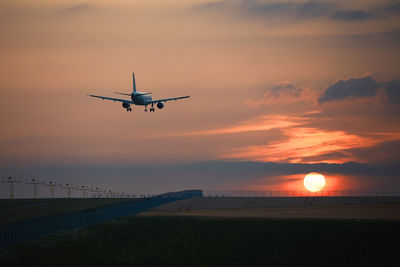 Airplane landing on airport runway at beautiful sunset. themes travel and aviation.