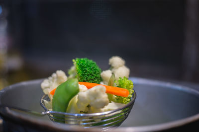 Close-up of vegetables in strainer over cooking utensil