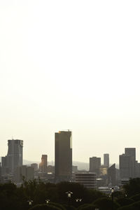 Buildings in city against clear sky