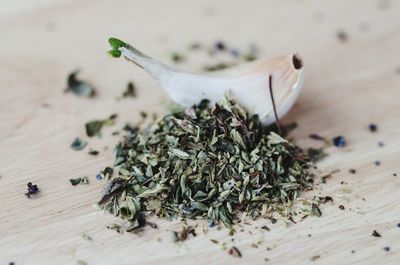 Garlic with oregano and poppy seeds on wooden table