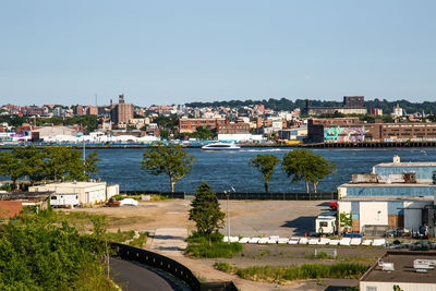 High angle view of buildings by river against sky