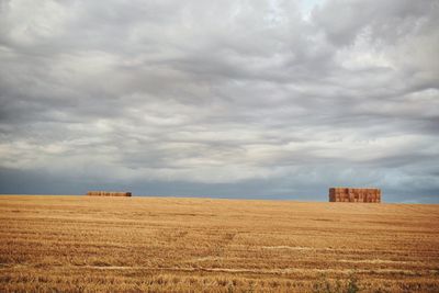 Scenic view of field against cloudy sky