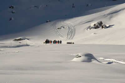 People skiing on snowcapped mountain during winter