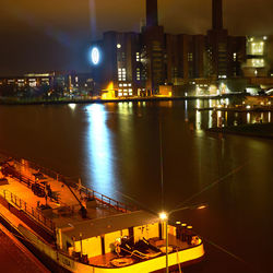 High angle view of illuminated buildings by river at night