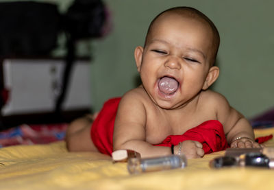 Cute baby girl lying on table at home