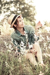 Woman looking away sitting on field