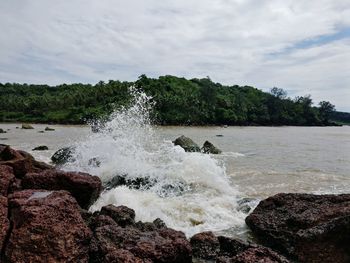 Scenic view of rocks in sea against sky