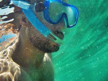 Close-up of shirtless man snorkeling in sea