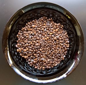 Directly above shot of coffee beans in bowl on table