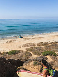 People at beach against sky