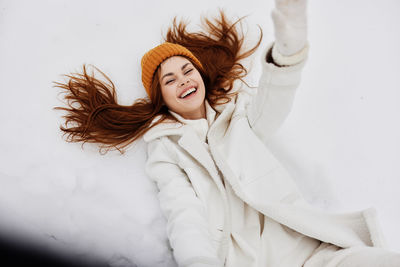 Portrait of young woman standing against white background