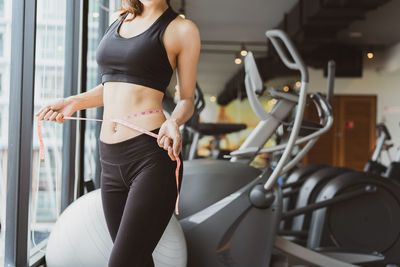 Midsection of young woman standing in front of building