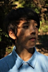 Close-up of boy looking away in park