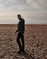 Man standing on beach against sky