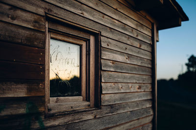 Glass window in log cabin during sunset