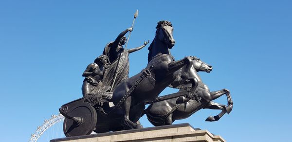 Low angle view of statue against clear blue sky