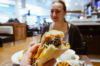 Close-up of fast food with woman in background at restaurant