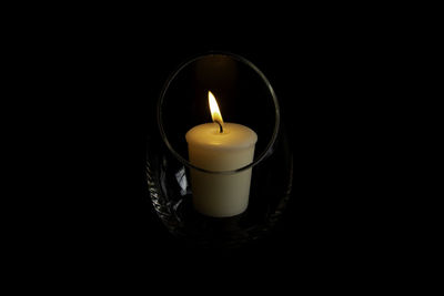 Close-up of illuminated candle against black background