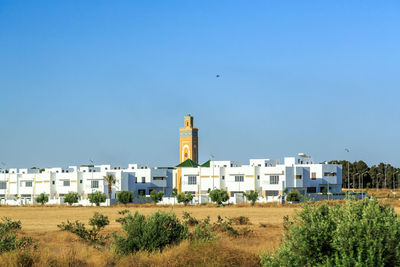 View of buildings against clear blue sky