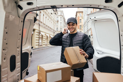 Portrait of smiling man holding mobile phone in bus