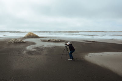 Man standing on beach against sky