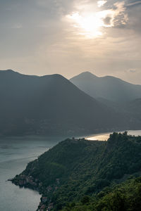 Scenic view of sea and mountains against sky during sunset