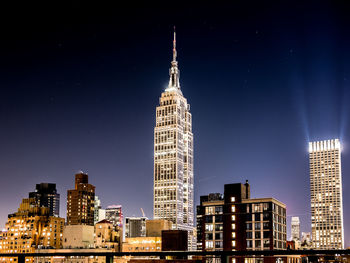 Illuminated buildings in city against sky at night