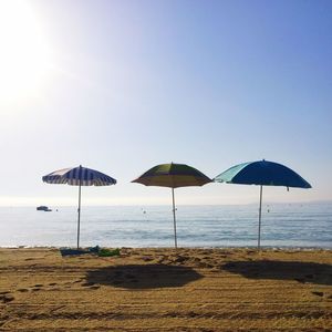 Umbrellas on beach against clear sky