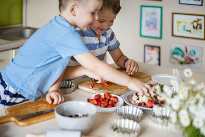 Cute kids eating food at kitchen