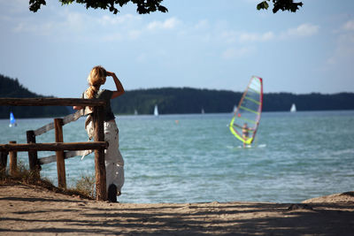 Woman in sea against sky