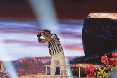 Side view of man standing against wall