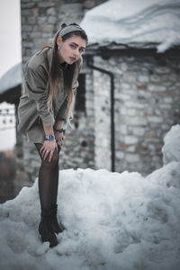 Portrait of young woman standing in snow