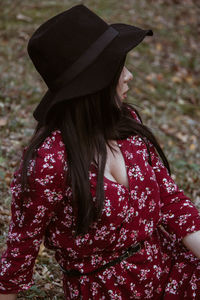 Woman wearing hat siting on field