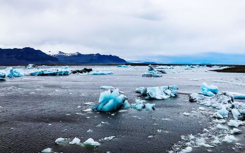 Scenic view of frozen sea shore against sky
