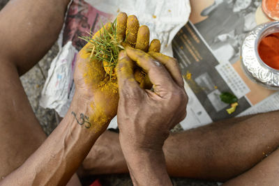 Midsection of man making religious offering during thaipusam