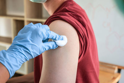 Midsection of woman getting vaccine in hospital