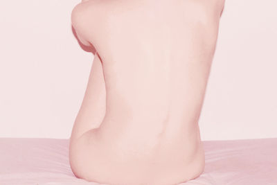 Low section of woman legs on bed over white background